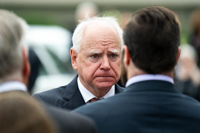 MINNEAPOLIS, MINNESOTA - JUNE 28: Minnesota Gov. Tim Walz presents a Minnesota flag to the family of DFL Rep. Melissa Hortman and her husband Mark Hortman after a funeral ceremony at the Basilica of Saint Mary on June 28, 2025 in Minneapolis, Minnesota. Law enforcement agencies captured Vance Boelter on June 15th in connection with the killing of Rep. Hortman and her husband, Mark, who were shot at their home on June 14th. DFL State Sen. John Hoffman and his wife were also shot and hospitalized in a separate incident. Minnesota Gov. Tim Walz said during a press conference that the shooting "appears to be a politically motivated assassination." (Photo by Stephen Maturen/Getty Images)