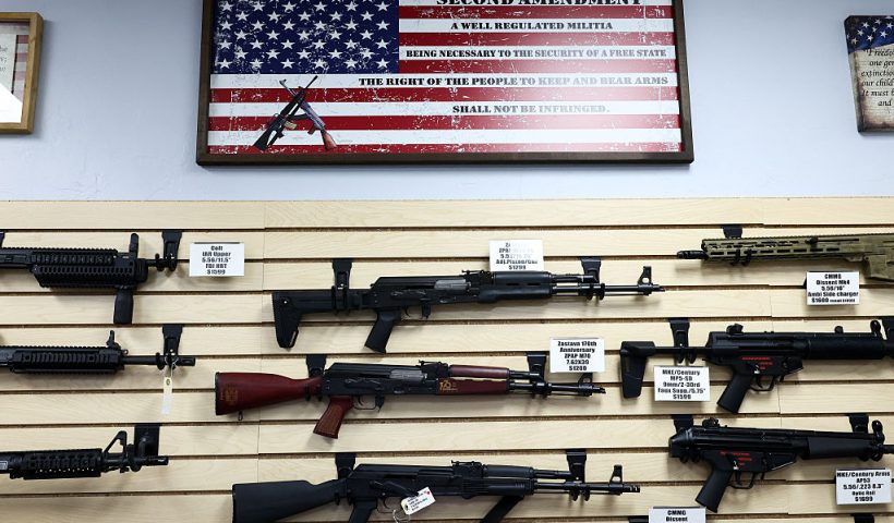 TOPSHOT - The second amendment (the right of the people to keep and bear arms) is spelled on a US flag above a display of firearms for sale in a gun store in Rio Rico, Santa Cruz County, Arizona on September 17, 2025. Arizona allows individuals legally eligible to own guns to carry them without a permit, background checks apply to dealer sales but not most private transactions. (Photo by CHARLY TRIBALLEAU / AFP) (Photo by CHARLY TRIBALLEAU/AFP via Getty Images)