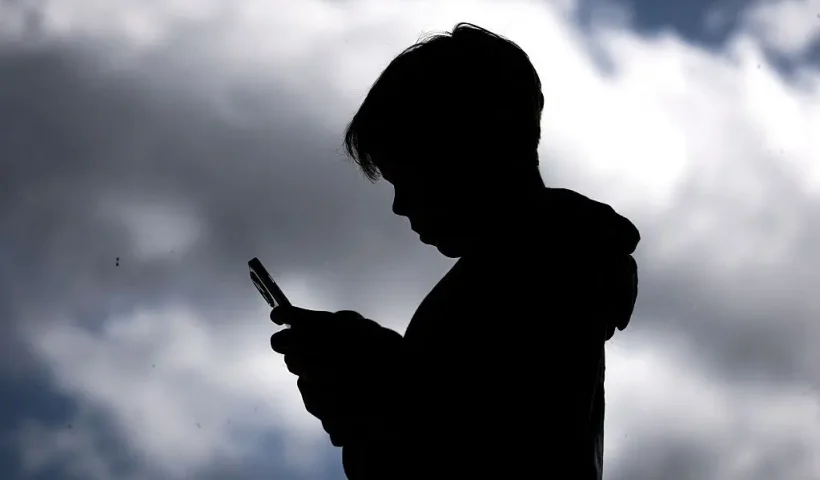 A 14-year-old boy posing at his home near Gosford as he looks at social media on his mobile phone. Tech giants Meta and TikTok said they will obey Australia's under-16 social media ban but warned the landmark laws could prove difficult to enforce. Australia will from December 10 force social media platforms such as Facebook, Instagram and TikTok to remove users under the age of 16. (Photo by David GRAY / AFP) (Photo by DAVID GRAY/AFP via Getty Images)