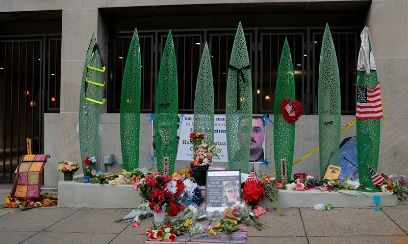 WASHINGTON, DC - DECEMBER 01: A makeshift memorial of flowers and American flags stands outside the Farragut West Metro station on December 01, 2025 in Washington, DC. Sarah Beckstrom, one of the two West Virginia National Guard troops who were shot blocks from the White House on November 26, died on Thursday, November 27, following what authorities called a targeted attack. (Photo by Heather Diehl/Getty Images)