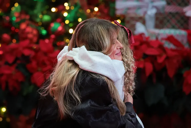 WASHINGTON, DC - DECEMBER 05: First lady Melania Trump hugs 5-year-old patient Faith Hinkle during a visit with patients and their families at Children’s National Hospital on December 5, 2025 in Washington, DC. The first lady visited the hospital to celebrate the winter holiday season and read children’s books to patients. (Photo by Anna Moneymaker/Getty Images)