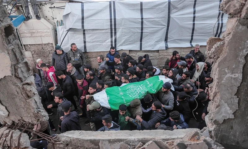 Mourners carry the body of Raid Saad, a commander of the Al-Qassam Brigades, during his funeral in the Al-Shati refugee camp in Gaza City, Gaza on December 14, 2025. Saad was killed in an Israeli airstrike that targeted a car west of Gaza City, according to Hamas. The strike occurred amid a ceasefire between Israel and Hamas. (Photo by Abood Abusalama / Middle East Images / AFP via Getty Images)
