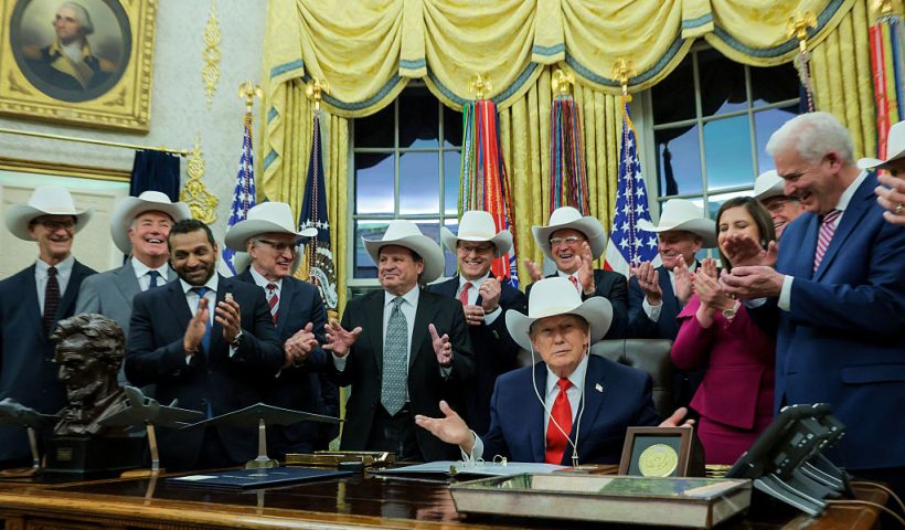 WASHINGTON, DC - DECEMBER 12: U.S. President Donald Trump puts on a hat given to him by the 1980 U.S. Olympic men’s ice hockey team as Trump honors the team in the Oval Office of the White House on December 13, 2025 in Washington, DC. Trump honored the ‘Miracle on Ice’ team, who defeated the Soviet Union and went on to win the 1980 Gold medal in Ice Hockey, by signing a bill to award the players congressional gold medals. (Photo by Anna Moneymaker/Getty Images)