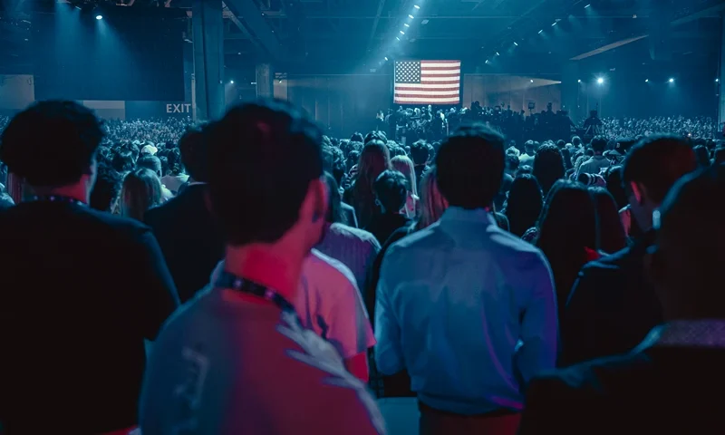Attendees face the US flag during the national anthem at Turning Point's annual AmericaFest conference, in remembrance of late right-wing political activist Charlie Kirk, in Phoenix, Arizona on December 18, 2025. (Photo by Olivier Touron / AFP via Getty Images)