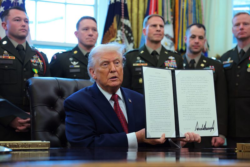 WASHINGTON, DC - DECEMBER 15: U.S. President Donald Trump poses with a recently signed executive order classifying fentanyl as a "weapon of mass destruction," during a ceremony for the presentation of the Mexican Border Defense Medal in the Oval Office of the White House on December 15, 2025 in Washington, DC. During the ceremony, Trump recognized the first 13 service members to receive the recently established Mexican Border Defense Medal (MBDM), which recognizes service members supporting Customs and Border Protection on the U.S.-Mexico border. (Photo by Anna Moneymaker/Getty Images)