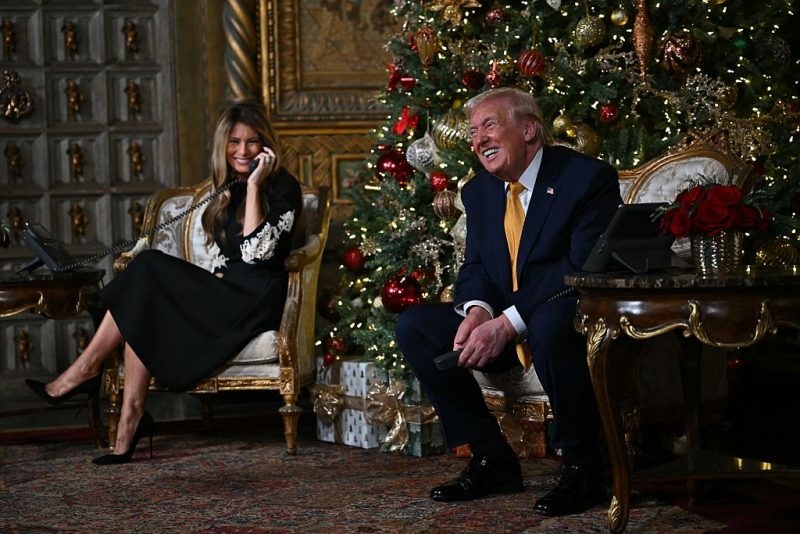 US President Donald Trump and first lady Melania Trump participate in NORAD Santa tracker phone calls, on Christmas Eve, from the Mar-a-lago club in Palm Beach, Florida, on December 24, 2025. (Photo by ANDREW CABALLERO-REYNOLDS / AFP via Getty Images)