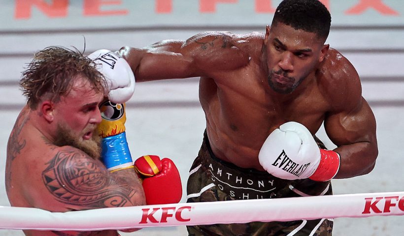 MIAMI, FLORIDA - DECEMBER 19: (L-R) Jake Paul fights Anthony Joshua in their heavyweight bout during Jake Paul v Anthony Joshua at Kaseya Center on December 19, 2025 in Miami, Florida. (Photo by Carmen Mandato/Getty Images for Netflix)
