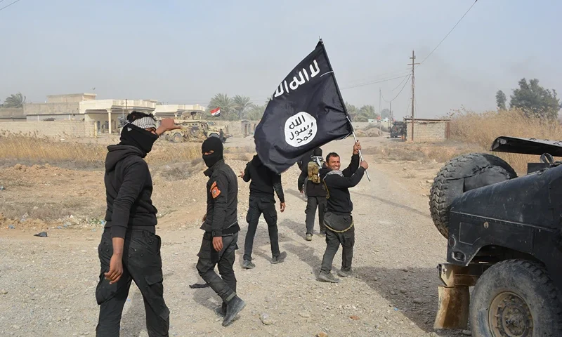 TOPSHOT - Iraqi government forces celebrate while holding an Islamis Sate (IS) group flag after they claimed they have gained complete control of the Diyala province, northeast of Baghdad, on January 26, 2015 near the town of Muqdadiyah. Iraqi forces have "liberated" Diyala province from the Islamic State jihadist group, retaking all populated areas of the eastern region, a top army officer said today. The symbolic victory for Baghdad, which has at times struggled to push IS back, could clear the way for further advances against the jihadists . AFP PHOTO / YOUNIS AL-BAYATI (Photo by YOUNIS AL-BAYATI / AFP) (Photo by YOUNIS AL-BAYATI/AFP via Getty Images)