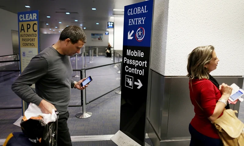 MIAMI, FL - MARCH 04: A sign points passengers to the mobile passport control window set up for international travelers arriving at Miami International Airport on March 4, 2015 in Miami, Florida. Miami-Dade Aviation Department and U.S. Customs and Border Protection (CBP) unveiled a new mobile app for expedited passport and customs screening. The app for iOS and Android devices allows U.S. citizens and some Canadian citizens to enter and submit their passport and customs declaration information using their smartphone or tablet and to help avoid the long waits in the exit lanes. (Photo by Joe Raedle/Getty Images)
