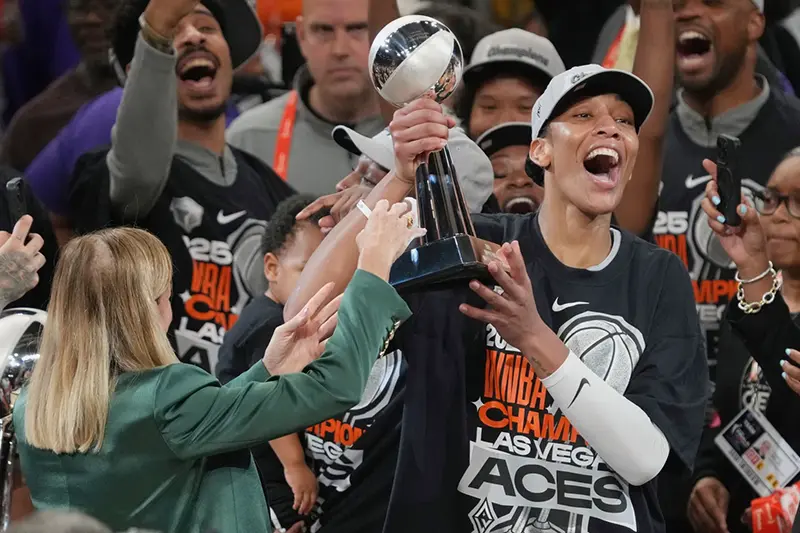 Las Vegas Aces center A’ja Wilson, center right, holds up her MVP trophy after Game 4 of the WNBA basketball finals against the Phoenix Mercury, Friday, Oct. 10, 2025, in Phoenix. (AP Photo/Rick Scuteri, File)