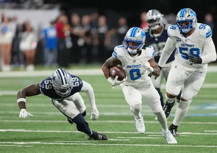 Detroit Lions running back Jahmyr Gibbs (0) runs the ball as Dallas Cowboys linebacker Jr. Kenneth Murray (59) tries to stop him during the first half of an NFL football game Thursday, Dec. 4, 2025, in Detroit.