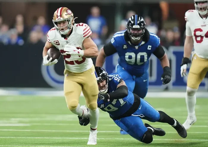 San Francisco 49ers running back Christian McCaffrey (23) runs past Indianapolis Colts defensive end Laiatu Latu (97) and defensive tackle Grover Stewart (90) during the first half of an NFL football game, Monday, Dec. 22, 2025, in Indianapolis. (AP Photo/AJ Mast)