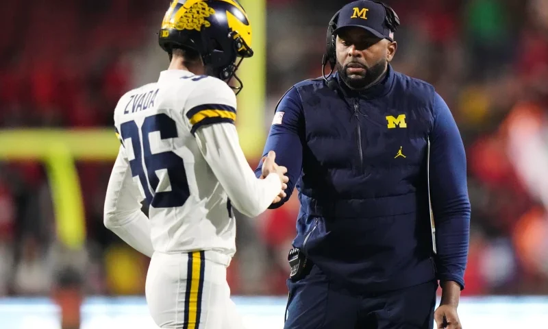 Michigan head coach Sherrone Moore celebrates with kicker Dominic Zvada (96) after an extra-point kick during the second half of an NCAA college football game against Maryland, Saturday, Nov. 22, 2025, in College Park, Md. (AP Photo/Stephanie Scarbrough)