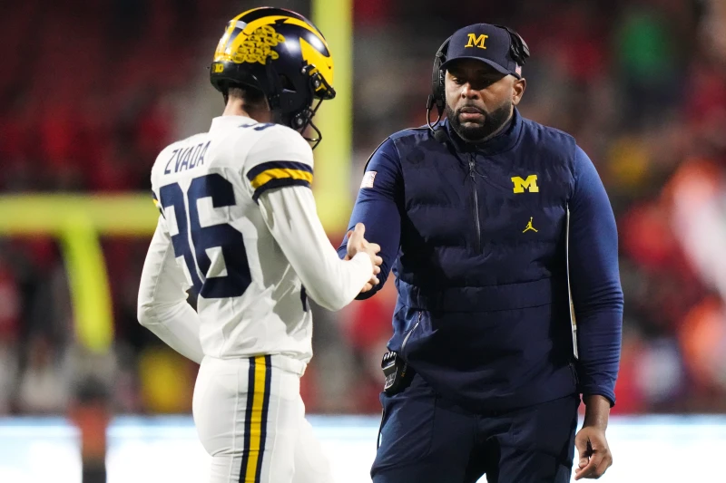 Michigan head coach Sherrone Moore celebrates with kicker Dominic Zvada (96) after an extra-point kick during the second half of an NCAA college football game against Maryland, Saturday, Nov. 22, 2025, in College Park, Md. (AP Photo/Stephanie Scarbrough)