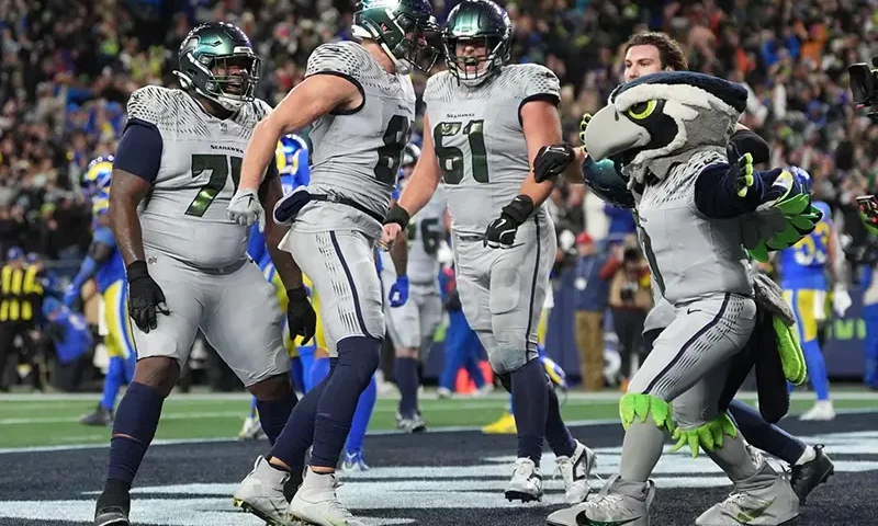 Seattle Seahawks tight end Eric Saubert, second from left, celebrates after making a two-point conversion during overtime in an NFL football game against the Los Angeles Rams, Thursday, Dec. 18, 2025, in Seattle. (AP Photo/Lindsey Wasson)