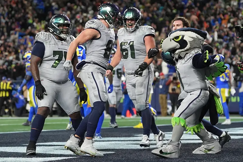 Seattle Seahawks tight end Eric Saubert, second from left, celebrates after making a two-point conversion during overtime in an NFL football game against the Los Angeles Rams, Thursday, Dec. 18, 2025, in Seattle. (AP Photo/Lindsey Wasson)