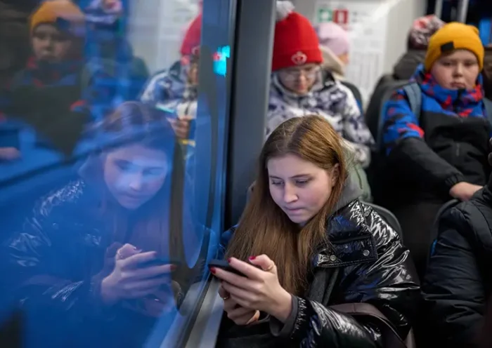 A woman looks at her smartphone on a bus in Moscow, Russia, Wednesday, Dec. 3, 2025. (AP Photo/Alexander Zemlianichenko, File)