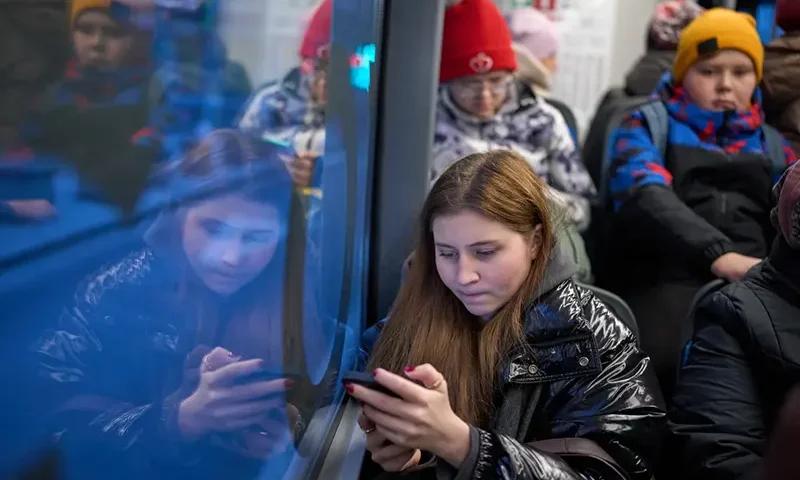 A woman looks at her smartphone on a bus in Moscow, Russia, Wednesday, Dec. 3, 2025. (AP Photo/Alexander Zemlianichenko, File)