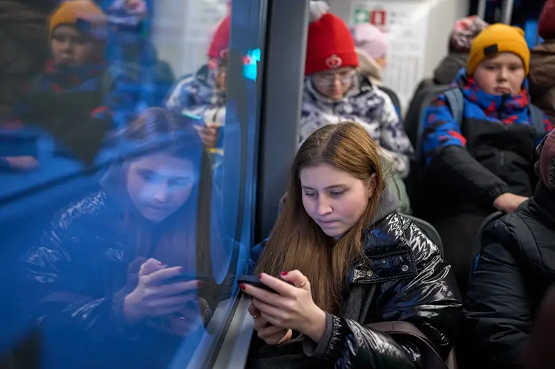 A woman looks at her smartphone on a bus in Moscow, Russia, Wednesday, Dec. 3, 2025. (AP Photo/Alexander Zemlianichenko, File)