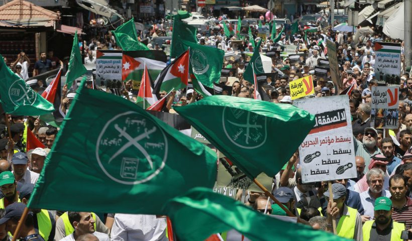 Flags of the Muslim Brotherhood, Jordan, and other political parties are waved with other protest signs denouncing the US-led Middle East economic conference in Bahrain, during a post-Friday prayers demonstration against US President Donald Trump's "Deal of the Century" in the Jordanian capital Amman on June 21, 2019. (Photo by Khalil MAZRAAWI / AFP) (Photo credit should read KHALIL MAZRAAWI/AFP via Getty Images)