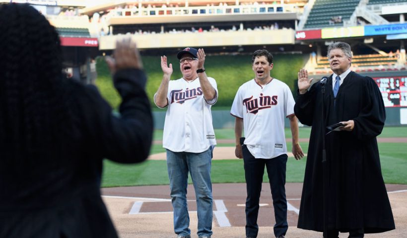 MINNEAPOLIS, MINNESOTA - SEPTEMBER 17: Minnesota Governor Tim Walz (left) and Minneapolis Mayor Jacob Frey celebrate as a judge swears in a new group of American citizens before the game between the Minnesota Twins and the Chicago White Sox at Target Field on September 17, 2019 in Minneapolis, Minnesota. (Photo by Hannah Foslien/Getty Images)