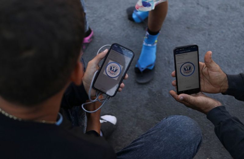 Venezuelan migrants browse the CBP One mobile app searching for an appointment to enter the United States outside the temporary stay of the National Migration Institute (INM) in Ciudad Juarez, Chihuahua state, Mexico, on May 5, 2023. Under the intense desert sun, among sand and brush, hundreds of migrants crossed the Rio Grande from Mexico on the rumor that the United States would let them in. But their hopes were dashed as they fell prey, once again, to misinformation. Falsehoods and deceptions add to the ordeal of these people, first to reach the border through Mexico and then to obtain asylum in the United States. (Photo by HERIKA MARTINEZ / AFP) (Photo by HERIKA MARTINEZ/AFP via Getty Images)