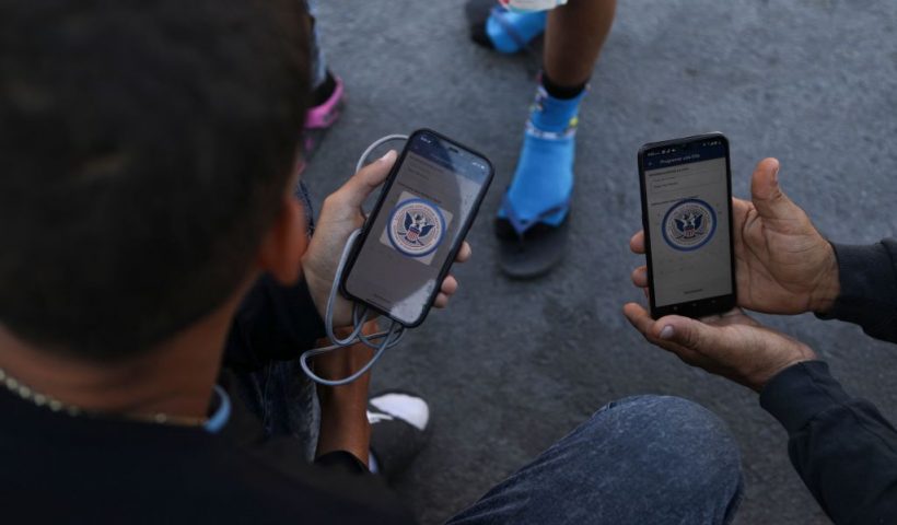 Venezuelan migrants browse the CBP One mobile app searching for an appointment to enter the United States outside the temporary stay of the National Migration Institute (INM) in Ciudad Juarez, Chihuahua state, Mexico, on May 5, 2023. Under the intense desert sun, among sand and brush, hundreds of migrants crossed the Rio Grande from Mexico on the rumor that the United States would let them in. But their hopes were dashed as they fell prey, once again, to misinformation. Falsehoods and deceptions add to the ordeal of these people, first to reach the border through Mexico and then to obtain asylum in the United States. (Photo by HERIKA MARTINEZ / AFP) (Photo by HERIKA MARTINEZ/AFP via Getty Images)