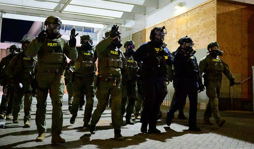 Federal agents keep protestors back from an Immigration and Customs Enforcement (ICE) facility in downtown Portland, Oregon, on October 6, 2025. President Donald Trump threatened on October 6, 2025, to use emergency powers against rebellion to deploy more troops into Democratic-led US cities, intensifying his rhetoric as his attempts to mobilize the military face legal challenges. Trump openly mulled use of the Insurrection Act after a federal judge in Oregon temporarily halted a National Guard deployment in Portland, while another judge in Illinois allowed a similar move to proceed for now in Chicago. (Photo by Mathieu Lewis-Rolland / AFP) (Photo by MATHIEU LEWIS-ROLLAND/AFP via Getty Images)