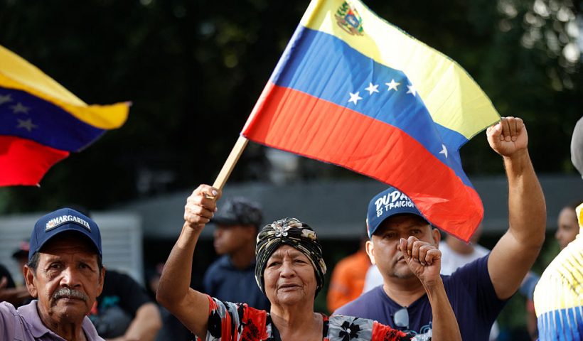 Supporters of Venezuela's President Nicolas Maduro flutter national flags in Caracas on January 3, 2026, after US forces captured Venezuelan leader Nicolas Maduro after launching a "large scale strike" on the South American country. President Donald Trump said Saturday that US forces had captured Maduro after bombing the capital Caracas and other cities in a dramatic climax to a months-long standoff between Trump and his Venezuelan arch-foe. (Photo by Pedro MATTEY / AFP via Getty Images)