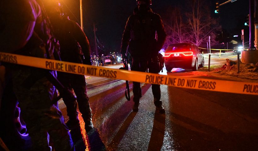 Federal law enforcement agents and police officers in riot gear stand behind a police tape as protests broke out following the shooting of a Venezuelan man by a Immigration and Customs Enforcement (ICE) agent in Minneapolis, Minnesota, on January 14, 2026. A federal immigration agent shot a man January 14 in Minneapolis, city officials said, urging the public to "remain calm" a week after agents shot and killed an American woman in the same city. Minneapolis Police Chief Brian O'Hara said the shooting resulted from a struggle in front of a residence between a man and an Immigration and Customs Enforcement (ICE) agent on the north side of the city. (Photo by Octavio JONES / AFP via Getty Images)