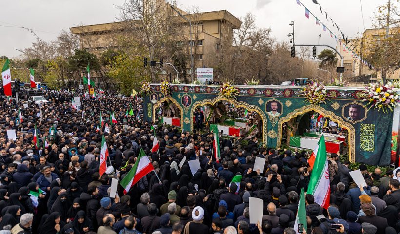 TEHRAN, IRAN - JANUARY 14: A crowd watches as the caskets of members of Iran's security forces, whom authorities said were killed during recent nationwide protests, are transported during a mass funeral on January 14, 2026 outside Tehran University in Tehran, Iran. The country has been gripped by a wave of anti-government protests and the ensuing crackdown, which rights groups say has left thousands of civilians dead. (Photo by Stringer/Getty Images)