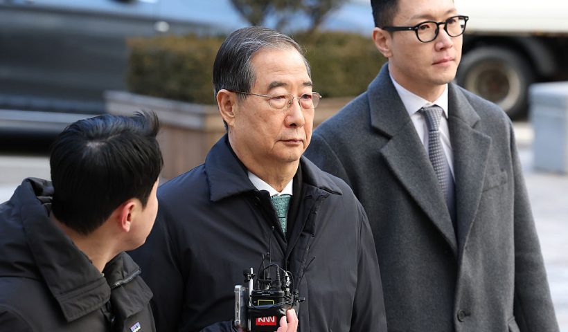 SEOUL, SOUTH KOREA - JANUARY 21: Former South Korean Prime Minister Han Duck-soo (C) arrives at the Seoul Central District Court for his first sentencing trial in the insurrection case on January 21, 2026 in Seoul, South Korea. A court is set to deliver a verdict Wednesday on charges that former Prime Minister Han Duck-soo played a key role in an insurrection by abetting former President Yoon Suk Yeol's failed imposition of martial law. (Photo by Chung Sung-Jun/Getty Images)