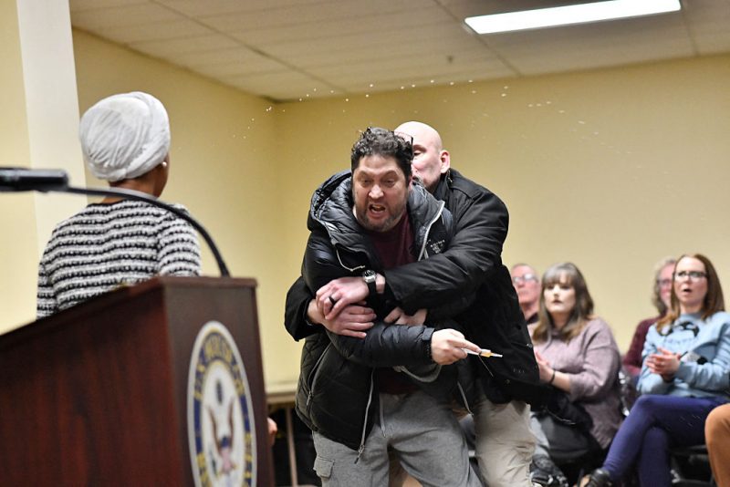 TOPSHOT - A man is tackled after spraying an unknown substance at US Representative Ilhan Omar (D-MN) (L) during a town hall she was hosting in Minneapolis, Minnesota, on January 27, 2026. (Photo by Octavio JONES / AFP via Getty Images)