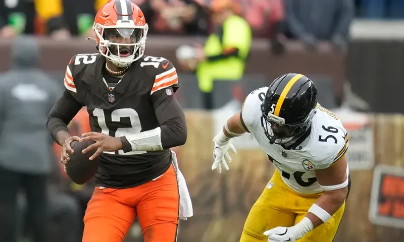 Cleveland Browns quarterback Shedeur Sanders (12) runs from Pittsburgh Steelers linebacker Alex Highsmith (56) during the second half of an NFL football game, Sunday, Dec. 28, 2025, in Cleveland. (AP Photo/Sue Ogrocki)