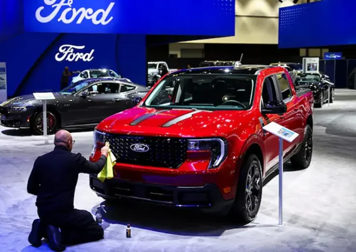 An employee polishes the 2025 Ford Maverick Hybrid pickup truck during the Los Angeles Auto Show, in Los Angeles, California, U.S., November 21, 2024. REUTERS/Daniel Cole