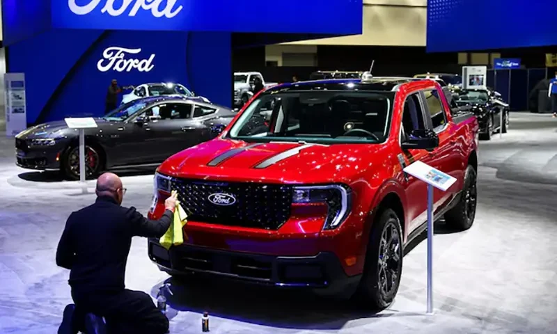 An employee polishes the 2025 Ford Maverick Hybrid pickup truck during the Los Angeles Auto Show, in Los Angeles, California, U.S., November 21, 2024. REUTERS/Daniel Cole