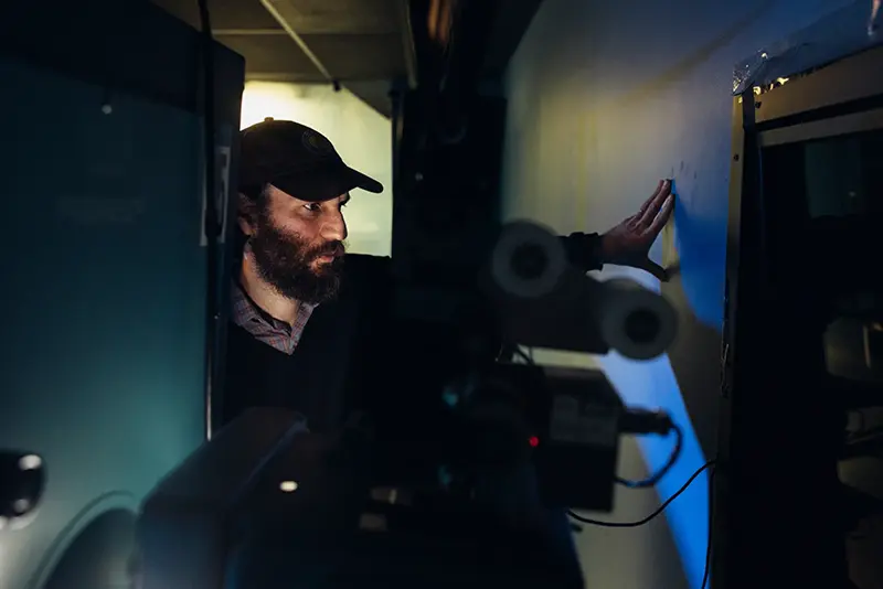 Josh Safdie poses for a portrait next to a 70mm projector on Monday, Dec. 15, 2025 in New York. (Photo by Victoria Will/Invision/AP)