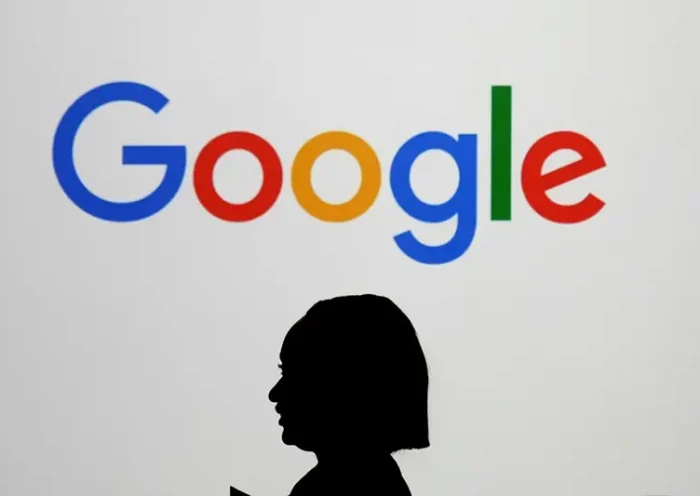 A woman walks by a giant screen with a logo at an event at the Paris Google Lab on the sidelines of the AI Action Summit in Paris, on Feb. 9, 2025. (AP Photo/Thibault Camus,File)