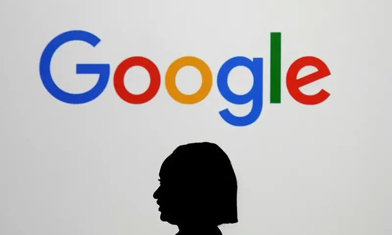 A woman walks by a giant screen with a logo at an event at the Paris Google Lab on the sidelines of the AI Action Summit in Paris, on Feb. 9, 2025. (AP Photo/Thibault Camus,File)