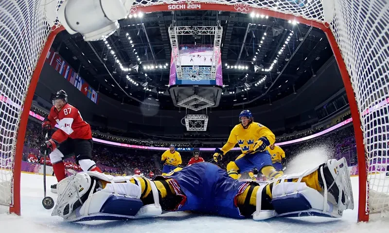 Canada forward Sidney Crosby, left, scores a goal past Sweden goaltender Henrik Lundqvist during the second period of the men’s gold medal ice hockey game, Feb. 23, 2014, at the Winter Olympics in Sochi, Russia. (AP Photo/Julio Cortez, Pool, FIle)