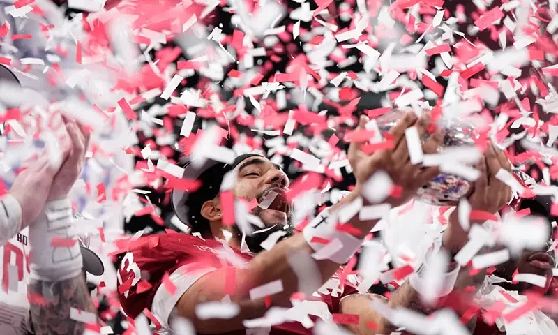Indiana wide receiver Elijah Sarratt (13) holds up the trophy after the Peach Bowl NCAA college football playoff semifinal against Oregon, Friday, Jan. 9, 2026, in Atlanta. (AP Photo/Brynn Anderson)