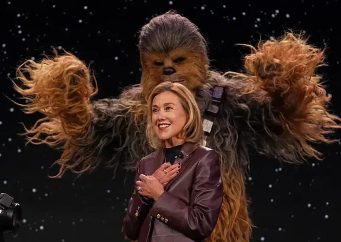 LEGO chief product and marketing officer and executive vice president Julia Goldin talks as a a Chewbacca stands behind her during an LEGO news conference ahead of the CES tech show Monday, Jan. 5, 2026, in Las Vegas. (AP Photo/Abbie Parr)