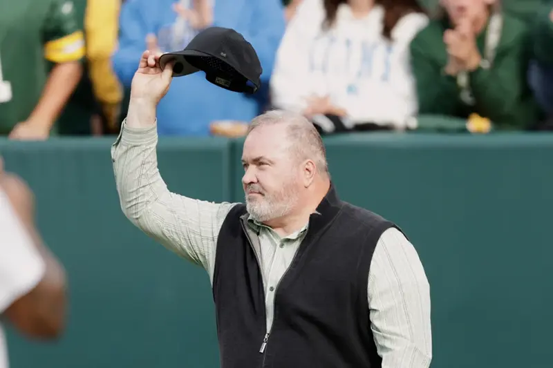 Former Green Bay Packers head coach Mike McCarthy waves during halftime of an NFL football game against the Detroit Lions Sunday, Sept. 7, 2025, in Green Bay, Wis. (AP Photo/Matt Ludtke, File)
