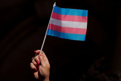 A person holds up a flag during rally to protest the Trump administration's reported transgender proposal to narrow the definition of gender to male or female at birth in New York. REUTERS/Brendan McDermid
